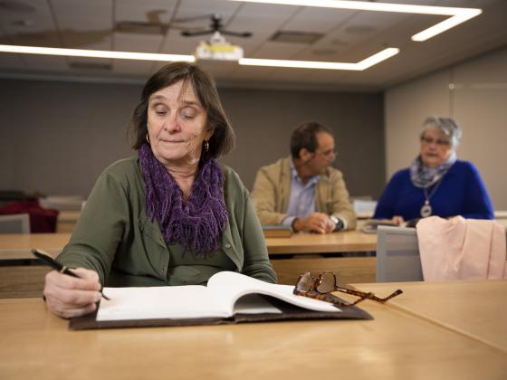 Donovan scholar writing on notepad in classroom