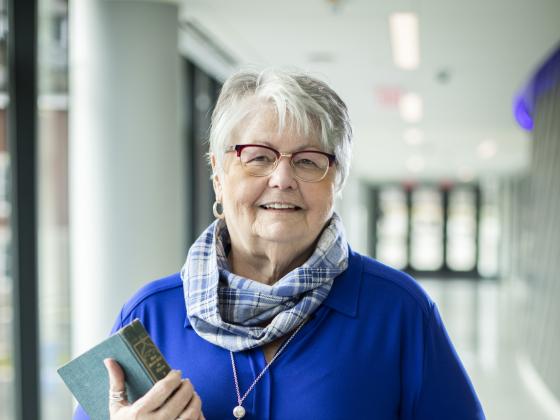 Donovan scholar holding book in hallway